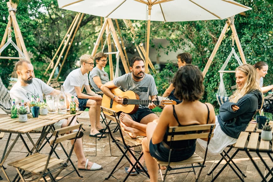 Guests relaxing together at Dreamsea France camp with live acoustic music
