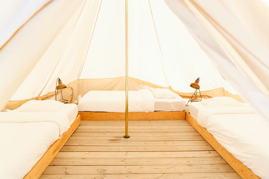 Shared tent interior at Dreamsea France with single beds and wooden floor