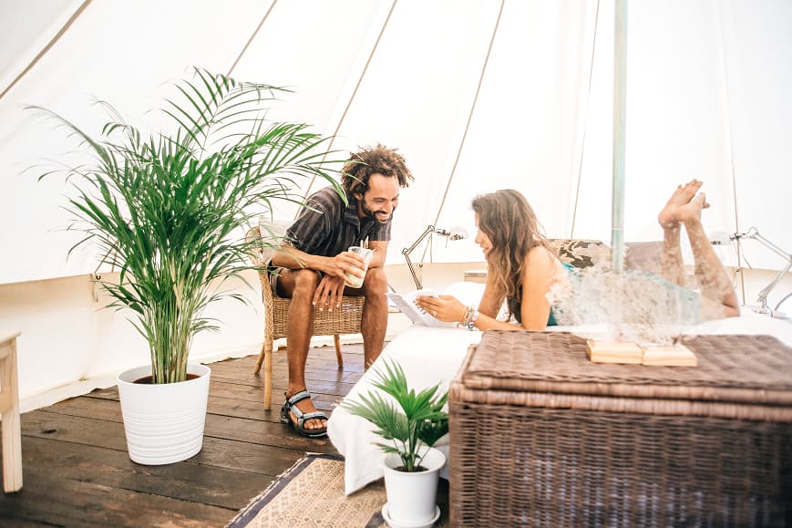 Couple relaxing inside a Dreamsea France glamping tent with natural decor