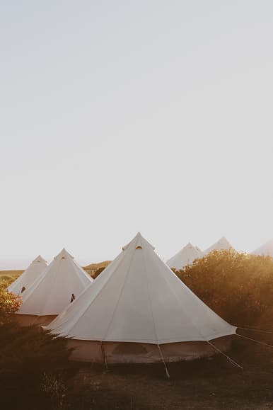 White glamping tents at Dreamsea Portugal Alentejo surrounded by nature at sunset