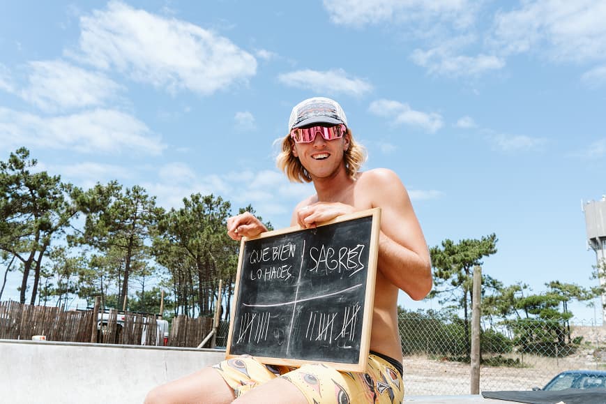 Guest holding a chalkboard during a camp game at Dreamsea Portugal Centro