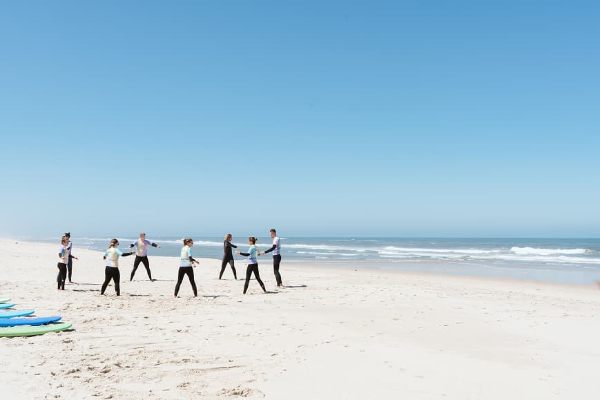 Surf group warming up on the wide sandy beach at Praia da Tocha