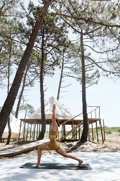 Outdoor yoga practice on a wooden deck beside the glamping tents at Dreamsea Portugal Centro