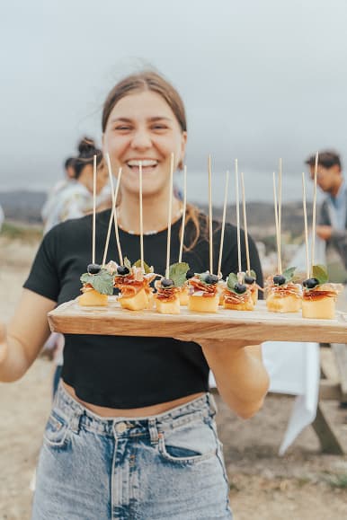 Huésped sirviendo aperitivos gourmet durante una experiencia en Dreamsea Cantabria