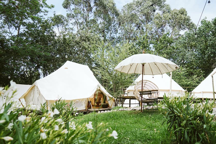 Tiendas glamping y zona de descanso al aire libre rodeadas de vegetación en Dreamsea Cantabria
