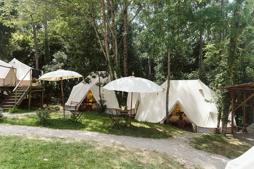 Tiendas tipo bell tent en una zona de camping sombreada y rodeada de naturaleza en Dreamsea Cantabria