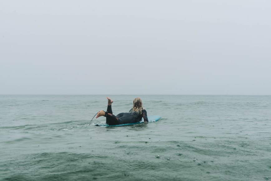 Surfista remando en aguas tranquilas durante una sesión de surf en Cantabria