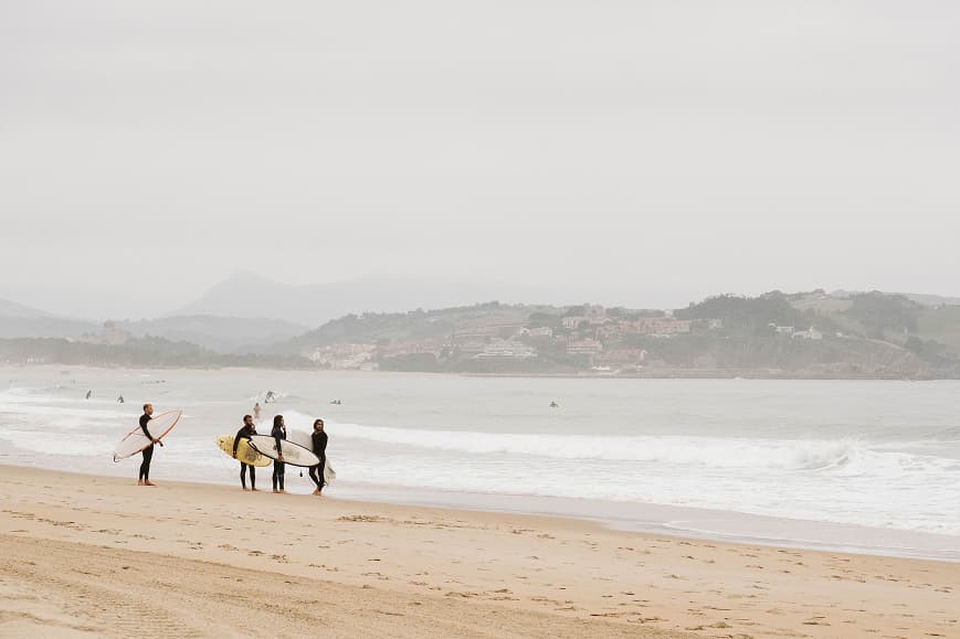 Grupo de surfistas en la playa con sus tablas en Cantabria
