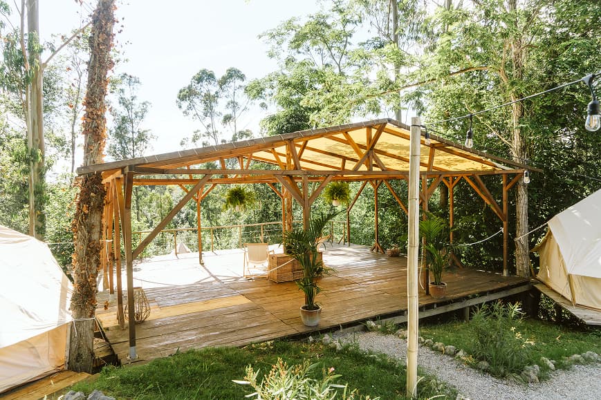Shala de yoga de madera al aire libre rodeada de árboles en Dreamsea Cantabria