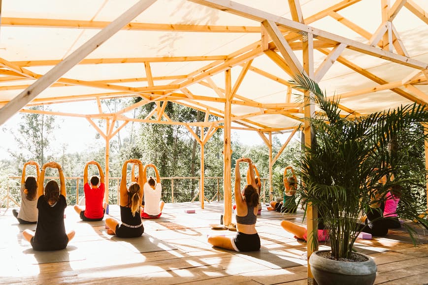 Clase grupal de yoga realizando estiramientos en la shala al aire libre de Dreamsea Cantabria