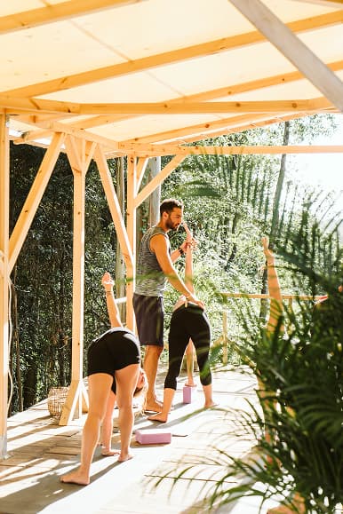 Instructor de yoga guiando una clase de estiramientos para huéspedes en Dreamsea Cantabria