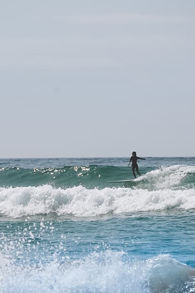 Longboard surfer riding a wave in the Atlantic Ocean near Dreamsea Portugal Alentejo