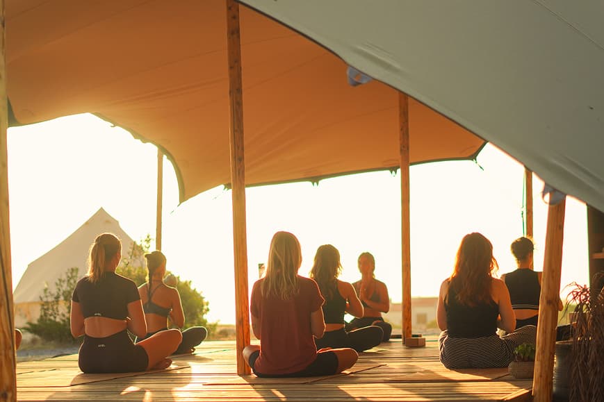 Group yoga and meditation session at sunset in the open-air shala