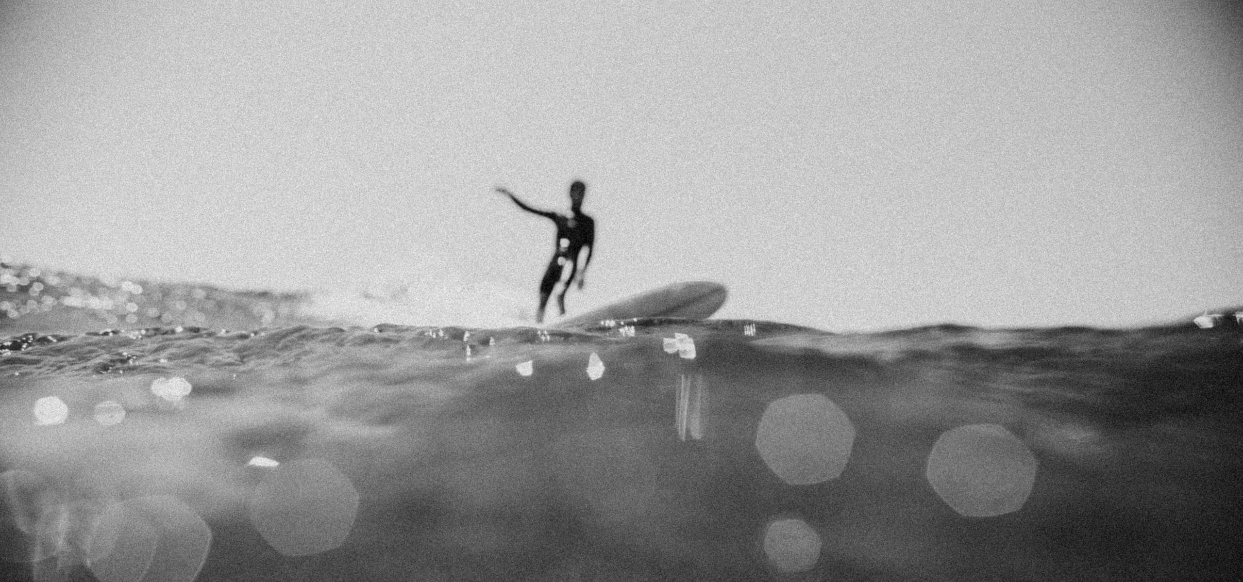 Surfer standing on a wave, seen from water level