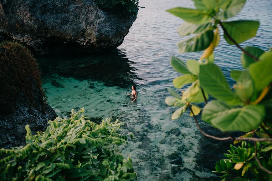 Guest swimming in clear ocean water near Uluwatu cliffs