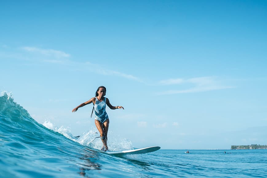 Surfer riding a clean blue wave near Dreamsea Bali Uluwatu