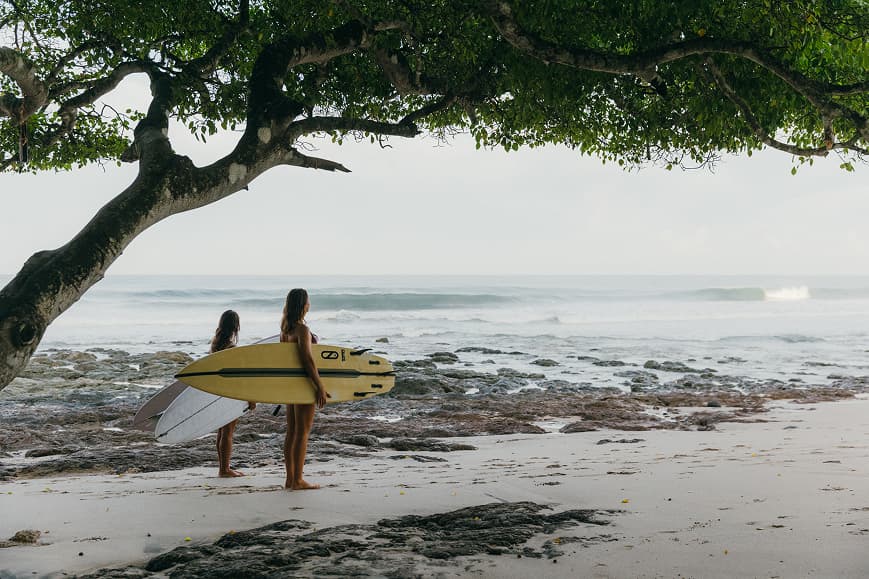 Two surfers watching the waves at Playa Avellanas Costa Rica