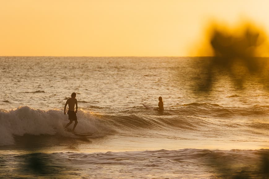 Surfers enjoying sunset waves on the Pacific coast of Costa Rica