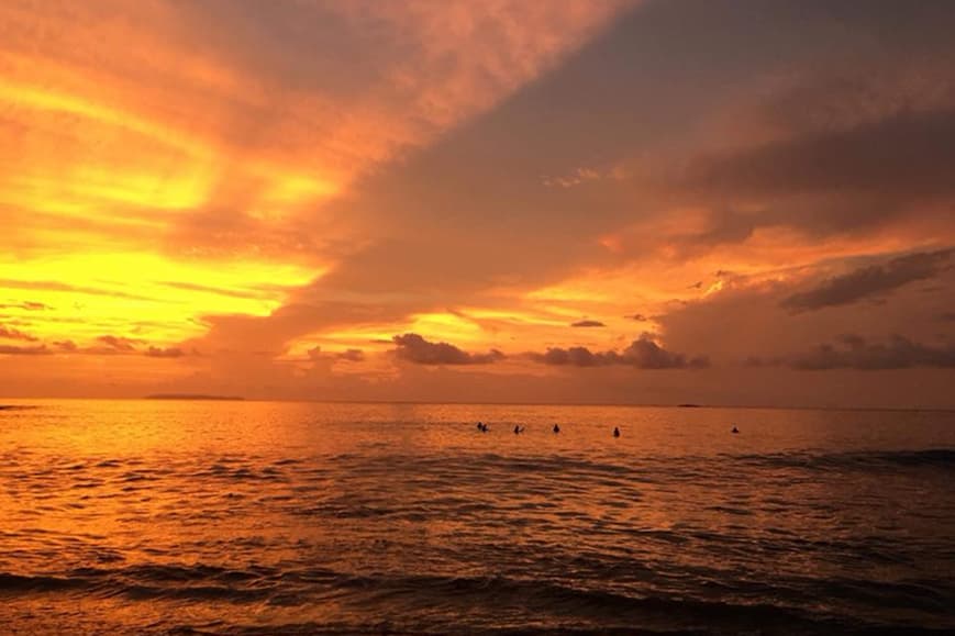 Ocean sunset over Playa Hermosa Santa Teresa with people in the water