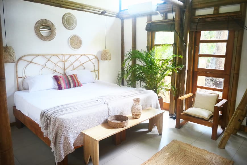 Private room at Dreamsea Santa Teresa with rattan decor and tropical garden views
