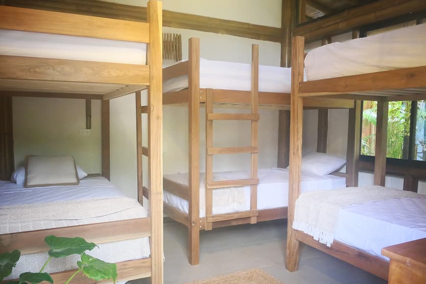 Shared dorm room at Dreamsea Santa Teresa with wooden bunk beds