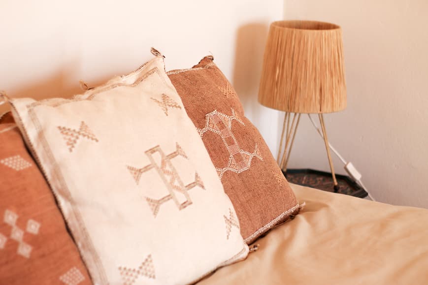 Moroccan-style pillows and bedside lamp in a Dreamsea Imsouane room