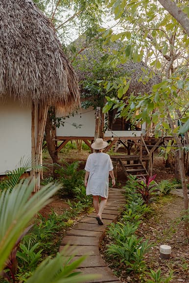 Guest walking between glamping cabins through the tropical garden at Dreamsea Nicaragua