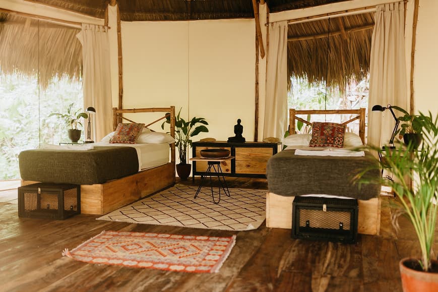 Twin glamping room at Dreamsea Nicaragua with wooden beds, tropical plants and natural decor
