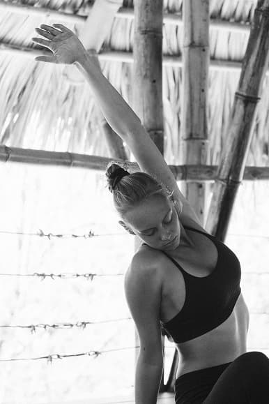 Guest stretching during yoga practice inside the bamboo shala at Dreamsea Nicaragua