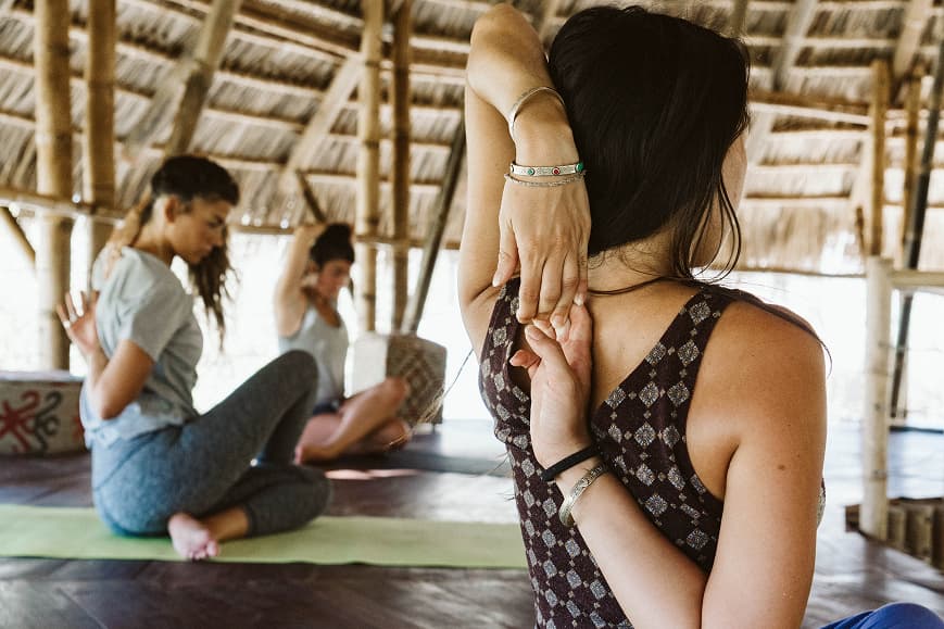 Group yoga class practicing shoulder stretches in the bamboo shala at Dreamsea Nicaragua