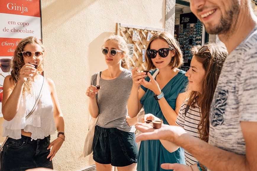 Guests tasting local ginjinha during a cultural experience in Portugal