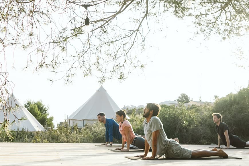 Group yoga class practicing upward-facing dog on an outdoor deck at Dreamsea Mediterranean