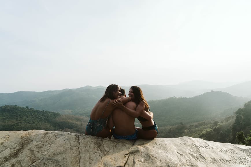 Friends sitting together on a viewpoint overlooking the Sri Lankan hills
