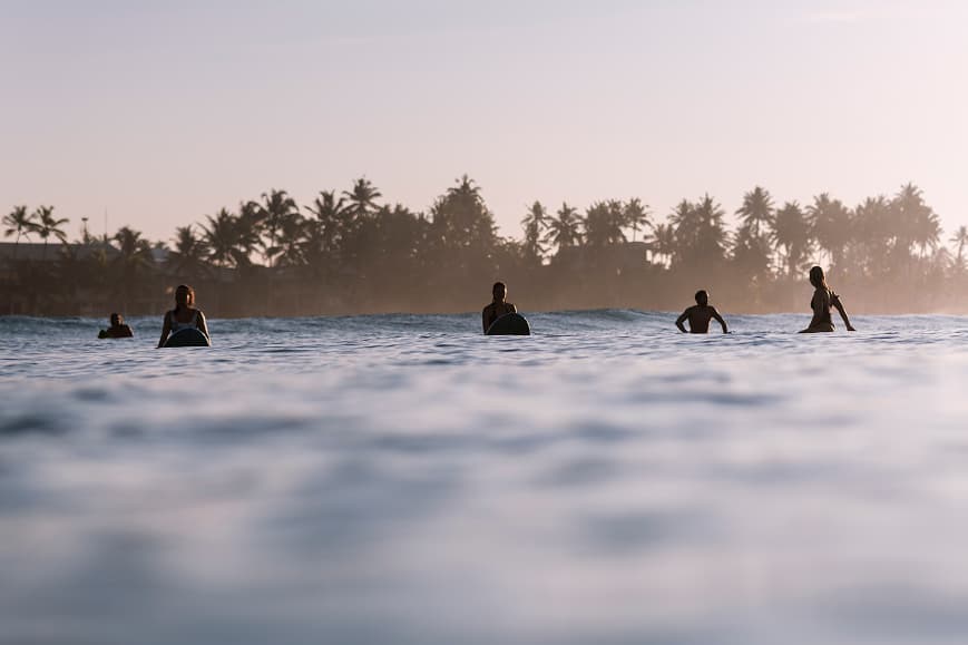Surfers waiting in the lineup at sunset on the south coast of Sri Lanka