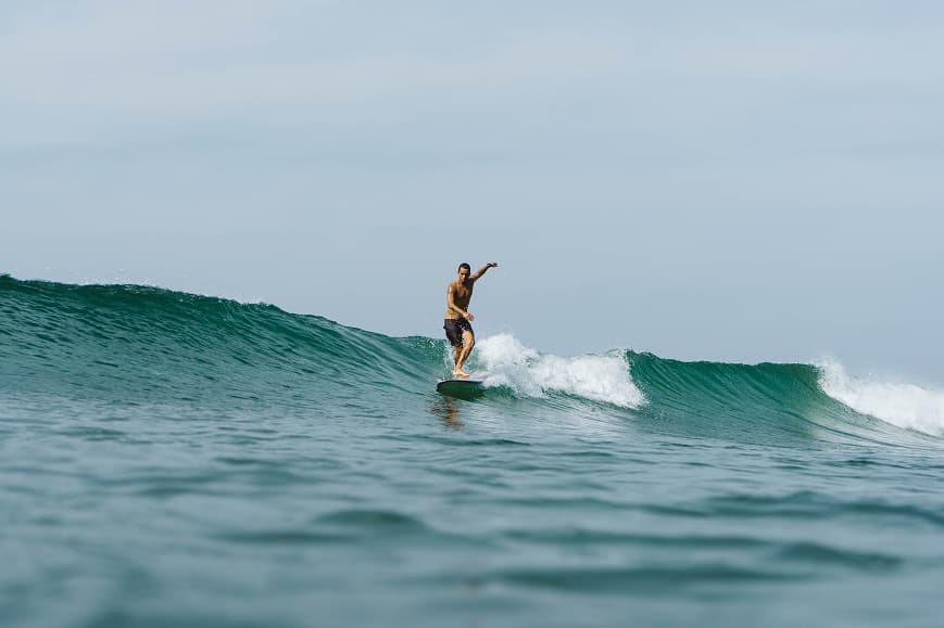 Longboard surfer riding a smooth wave on the south coast of Sri Lanka
