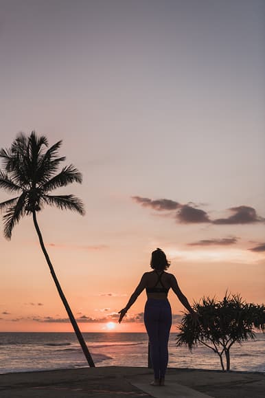 Guest practicing yoga at sunset beside the ocean in Sri Lanka