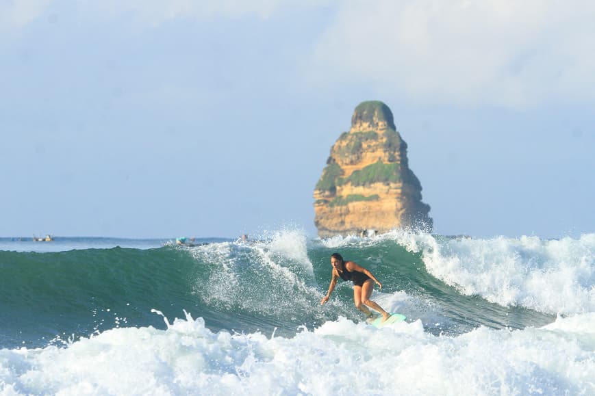Surfer riding a clean wave in Lombok